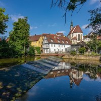 Die Rems in Waiblingen mit Fachwerkh&auml;usern und einer Kirche im Hintergrund, umgeben von B&auml;umen und blauem Himmel., &copy; Remstal Tourismus e.V.