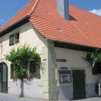 Historisches Gebäude mit rotem Ziegeldach, grünen Fensterläden und Weinreben an der Fassade. Ein Schild weist auf die "Alte Kelterstraße" hin., © Land der 1000 Hügel - Kraichgau-Stromberg Historisches Gebäude mit rotem Ziegeldach, grünen Fensterläden und Weinreben an der Fassade. Ein Schild weist auf die "Alte Kelterstraße" hin., © Land der 1000 Hügel - Kraichgau-Stromberg