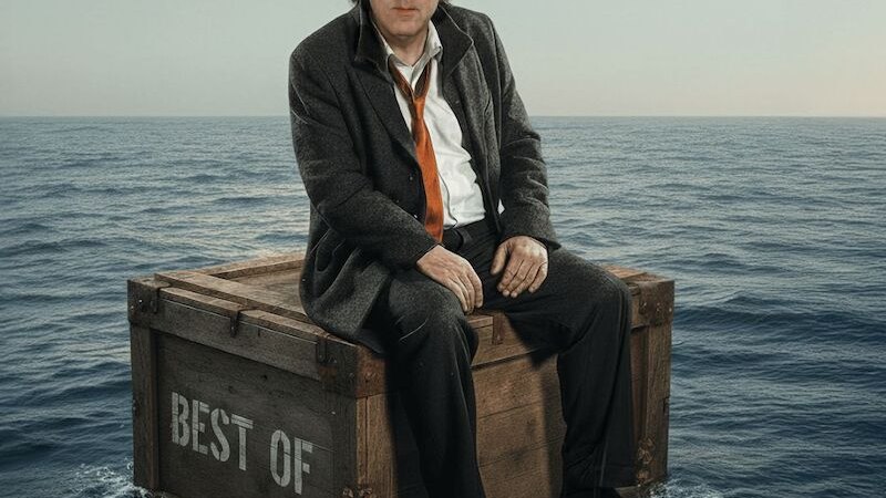 Ein Mann steht im Regen, tr&auml;gt einen nassen Mantel und eine orangefarbene Krawatte. Er blickt nach oben, w&auml;hrend der Regen auf ihn f&auml;llt., &copy; Mauerwerk GmbH