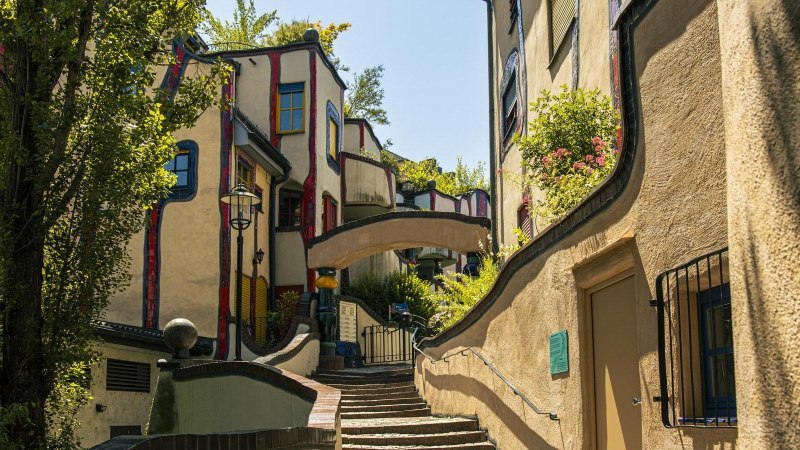 Das Hundertwasserhaus in Plochingen zeigt seine charakteristische, bunte und wellenförmige Architektur mit üppiger Begrünung und geschwungenen Wegen., © SMG, Sarah Schmid Das Hundertwasserhaus in Plochingen zeigt seine charakteristische, bunte und wellenförmige Architektur mit üppiger Begrünung und geschwungenen Wegen., © SMG, Sarah Schmid