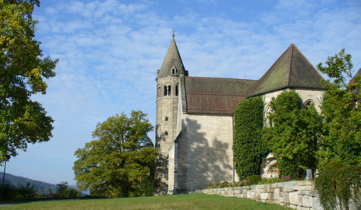 Das Bild zeigt das Kloster Lorch mit einem markanten Turm, umgeben von Bäumen und einer Wiese unter blauem Himmel., © Remstal Tourismus e.V.