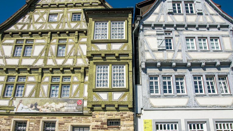 Zwei historische Fachwerkh&auml;user am Marktplatz in B&ouml;blingen, eines in Gr&uuml;n und das andere in Grau, bei klarem Himmel., &copy; Stuttgart-Marketing GmbH, Sarah Schmid