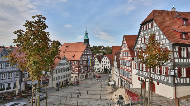 Der Marktplatz in Backnang zeigt malerische Fachwerkh&auml;user und einen gepflasterten Platz. Im Hintergrund ist ein Turm mit gr&uuml;nem Dach zu sehen., &copy; Edgar Layher Fotografie