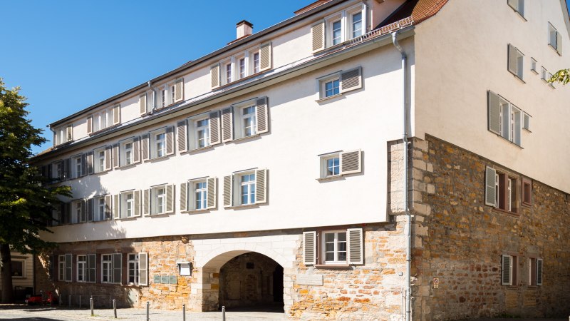 Historisches Geb&auml;ude mit Steinmauer und wei&szlig;en Fensterl&auml;den, umgeben von B&auml;umen, unter blauem Himmel in G&ouml;ppingen., &copy; Stadtmarketing G&ouml;ppingen