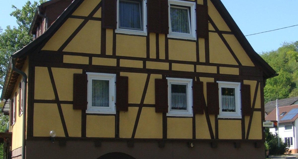 Fachwerkhaus mit gelber Fassade und braunen Balken, an einer Straße gelegen. Vor dem Haus stehen Pflanzen in Töpfen., © Land der 1000 Hügel - Kraichgau-Stromberg Fachwerkhaus mit gelber Fassade und braunen Balken, an einer Straße gelegen. Vor dem Haus stehen Pflanzen in Töpfen., © Land der 1000 Hügel - Kraichgau-Stromberg