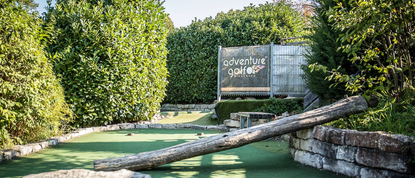 Adventure-Golfanlage in Winnenden mit grünem Kunstrasen und Holzhindernis, umgeben von üppigem Grün., © Adventuregolf Winnenden Adventure-Golfanlage in Winnenden mit grünem Kunstrasen und Holzhindernis, umgeben von üppigem Grün., © Adventuregolf Winnenden
