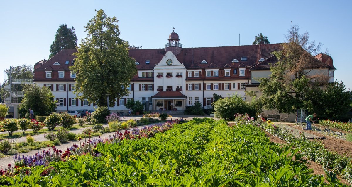Das Christliche Gästezentrum Schönblick mit rotem Dach und Uhrturm, umgeben von blühenden Gärten und Bäumen, bei strahlendem Sonnenschein., © Mario Klaiber Das Christliche Gästezentrum Schönblick mit rotem Dach und Uhrturm, umgeben von blühenden Gärten und Bäumen, bei strahlendem Sonnenschein., © Mario Klaiber