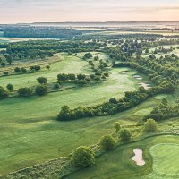 Luftaufnahme des Golfclubs Domäne Niederreutin mit gepflegten Fairways, Bunkern und Clubhaus im Hintergrund bei Sonnenuntergang., © Golfclub Domäne Niederreutin
