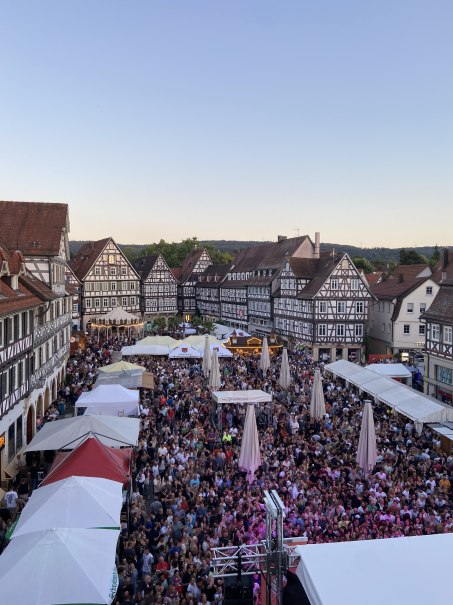 Große Menschenmenge auf einem Platz in Schorndorf, umgeben von historischen Fachwerkhäusern. Zelte und Stände sind aufgebaut, der Himmel ist klar., © Stadt Schorndorf Große Menschenmenge auf einem Platz in Schorndorf, umgeben von historischen Fachwerkhäusern. Zelte und Stände sind aufgebaut, der Himmel ist klar., © Stadt Schorndorf