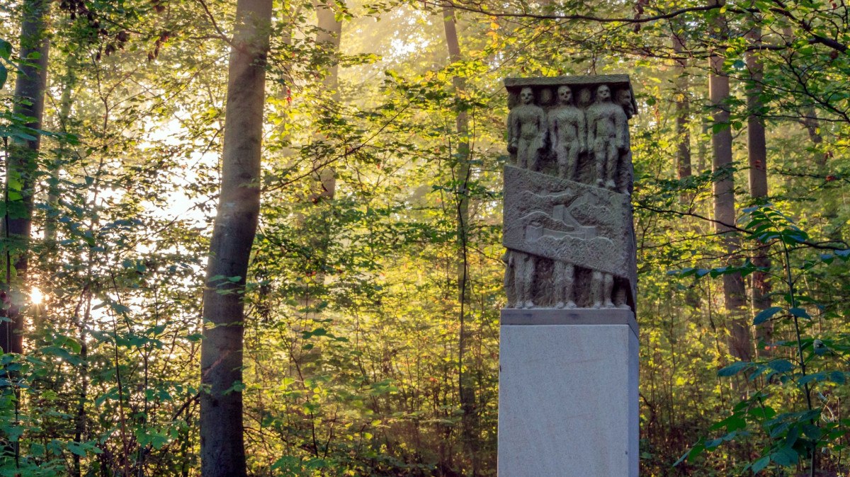 Eine Steinskulptur steht im Wald, umgeben von B&auml;umen und durchflutet von Sonnenstrahlen. Die Skulptur zeigt menschliche Figuren und Reliefs., &copy; Schw&auml;bischer Albverein, Ortsgruppe B&ouml;blingen