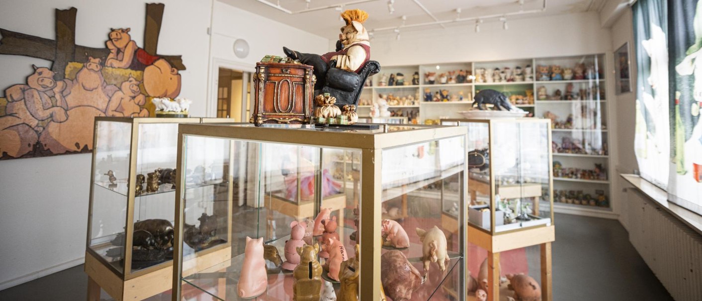 Ein Raum im Schweinemuseum Stuttgart mit Vitrinen voller Schweinefiguren und einem großen Wandbild von Schweinen., © Stuttgart-Marketing GmbH, Sarah Schmid Ein Raum im Schweinemuseum Stuttgart mit Vitrinen voller Schweinefiguren und einem großen Wandbild von Schweinen., © Stuttgart-Marketing GmbH, Sarah Schmid
