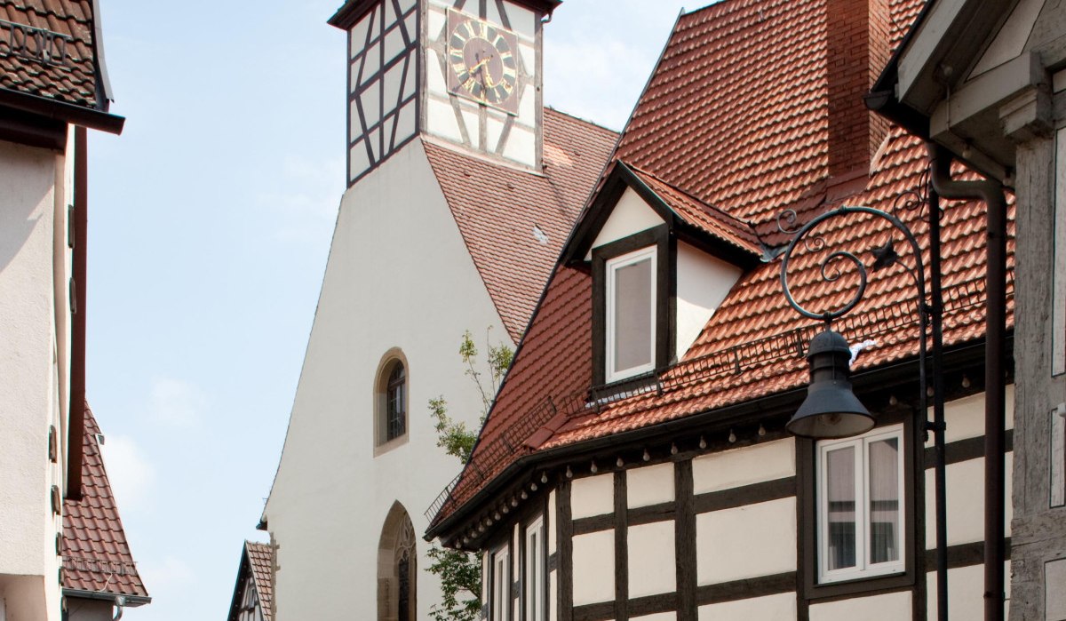 Die Nikolauskirche mit ihrem markanten Turm und umliegenden Fachwerkhäusern in einer malerischen Altstadtgasse., © Waiblingen - Stuttgart-Marketing GmbH Die Nikolauskirche mit ihrem markanten Turm und umliegenden Fachwerkhäusern in einer malerischen Altstadtgasse., © Waiblingen - Stuttgart-Marketing GmbH