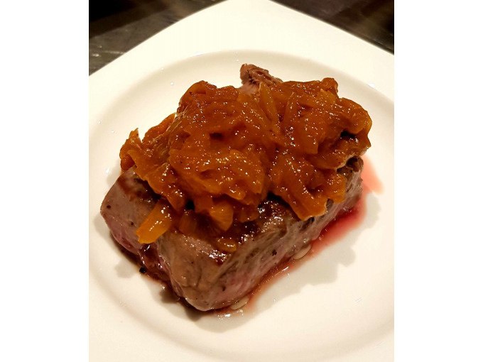 Ein saftiges St&uuml;ck Fleisch, garniert mit einer Zwiebelsauce, serviert auf einem wei&szlig;en Teller., &copy; Kultweine-Kochwelten-Kunst&uuml;cke - Kochschule Sonja Lenz