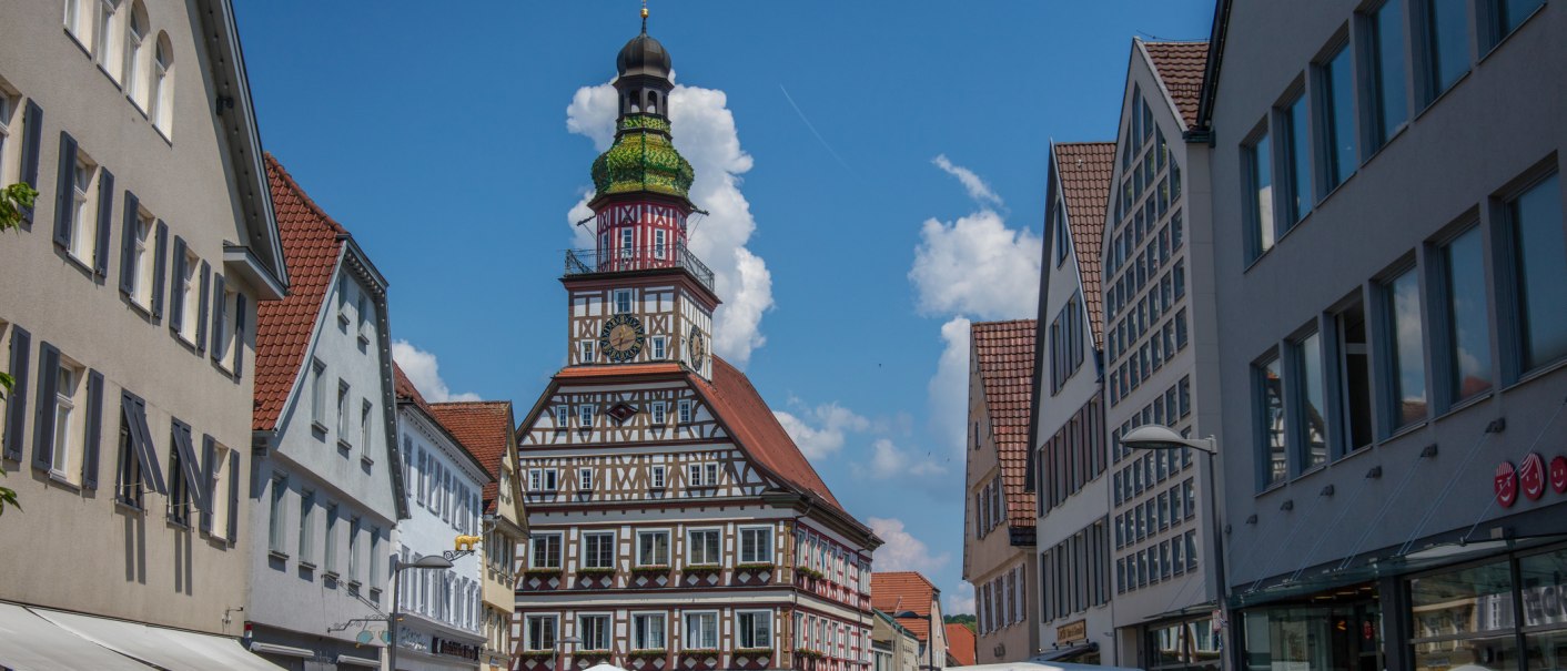 Ein historisches Fachwerk-Rathaus in einer deutschen Stadt, umgeben von modernen Gebäuden. Der Himmel ist blau mit einigen Wolken., © Stadt Kirchheim unter Teck Ein historisches Fachwerk-Rathaus in einer deutschen Stadt, umgeben von modernen Gebäuden. Der Himmel ist blau mit einigen Wolken., © Stadt Kirchheim unter Teck