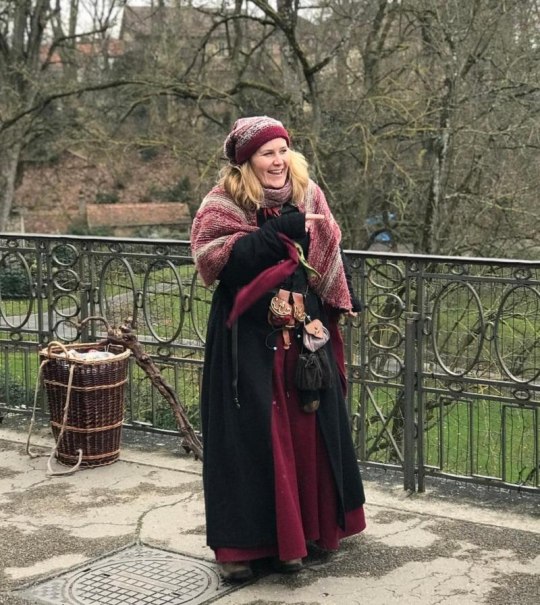Eine Frau in mittelalterlicher Kleidung steht auf einer Br&uuml;cke. Sie tr&auml;gt einen Umhang und hat einen Korb und einen Stock bei sich., &copy; Tourist Information und Ticket Service Ludwigsburg