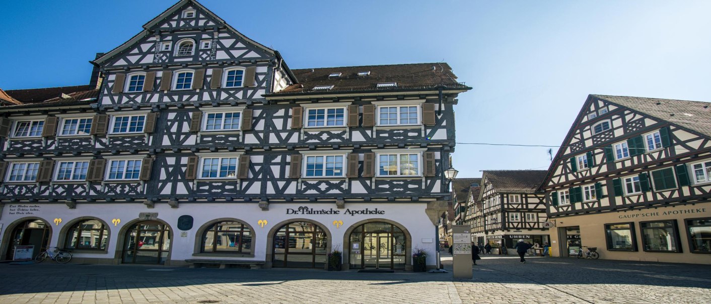 Fachwerkhäuser am Schorndorfer Marktplatz, darunter die Dr. Palmsche Apotheke. Sonniger Tag, klare blaue Himmel., © SMG, Sarah Schmid Fachwerkhäuser am Schorndorfer Marktplatz, darunter die Dr. Palmsche Apotheke. Sonniger Tag, klare blaue Himmel., © SMG, Sarah Schmid