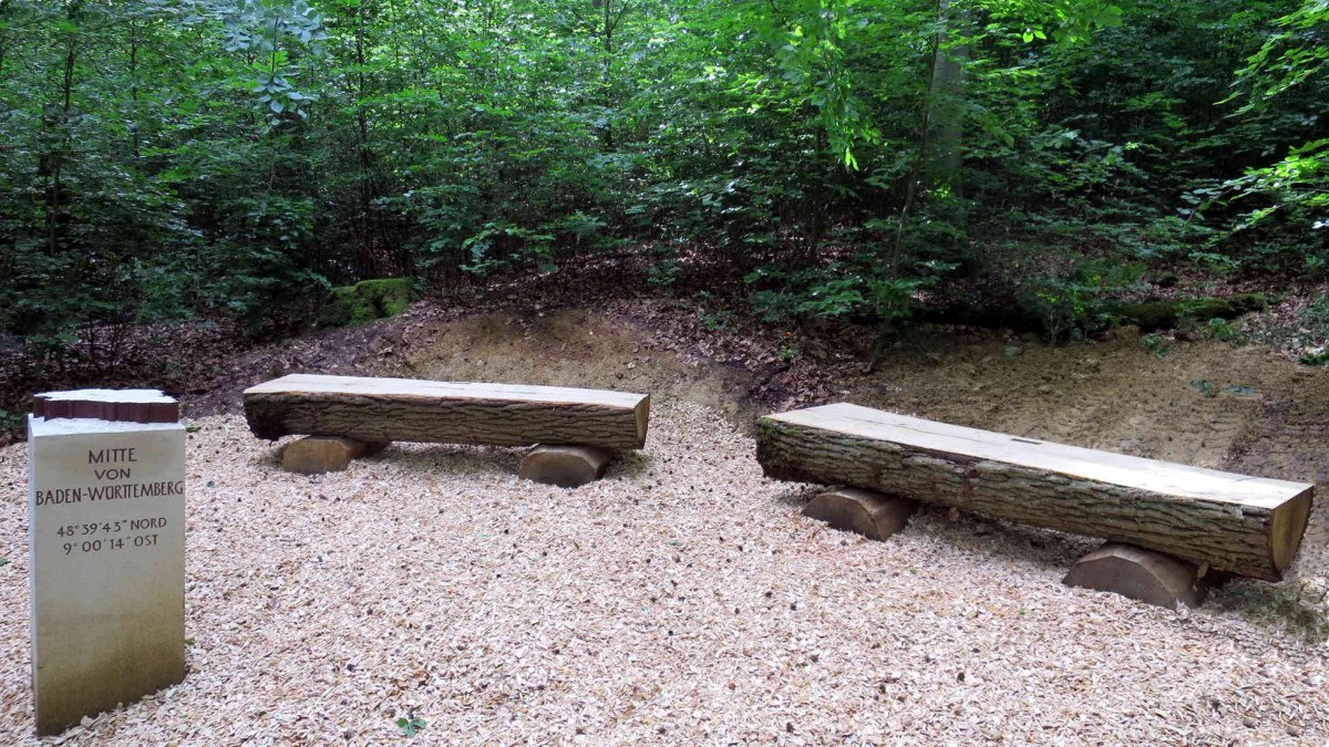 Sandsteinsäule mit Inschrift "Mitte von Baden-Württemberg" und zwei Holzbänke im Wald auf Holzschnitzeln., © Schwäbischer Albverein, Ortsgruppe Böblingen