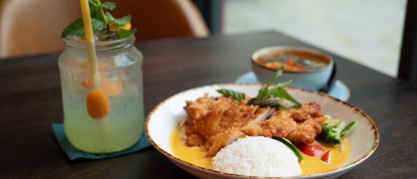 Ein Teller mit Reis, frittiertem H&auml;hnchen und Gem&uuml;se in Curryso&szlig;e. Daneben ein erfrischendes Getr&auml;nk mit Minze in einem Glas., &copy; Lunar
