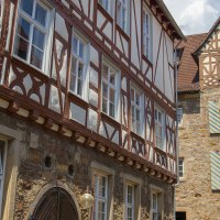 Fachwerkgebäude in Kirchheim unter Teck mit verzierten Fenstern und Türen. Historische Architektur mit roten und weißen Balken., © Achim Mende