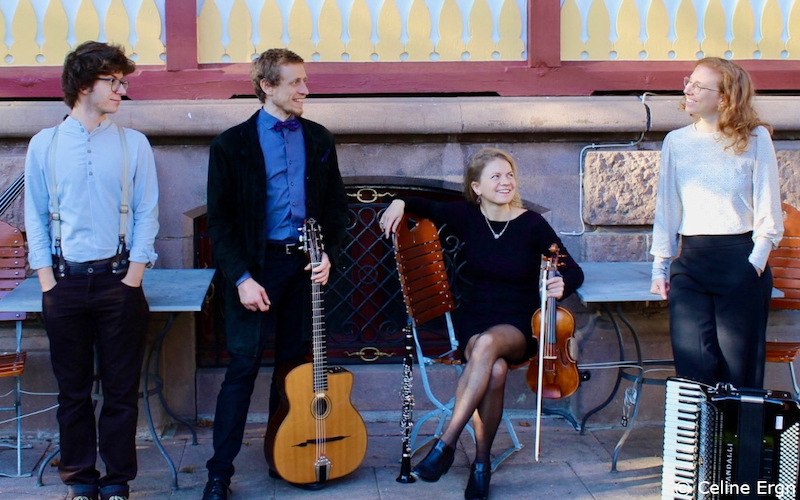 Vier Musiker mit Gitarre, Geige, Klarinette und Akkordeon posieren lächelnd vor einer Steinmauer. Sie tragen elegante Kleidung., © Kultur- und Sportamt Stadt Bietigheim-Bissingen