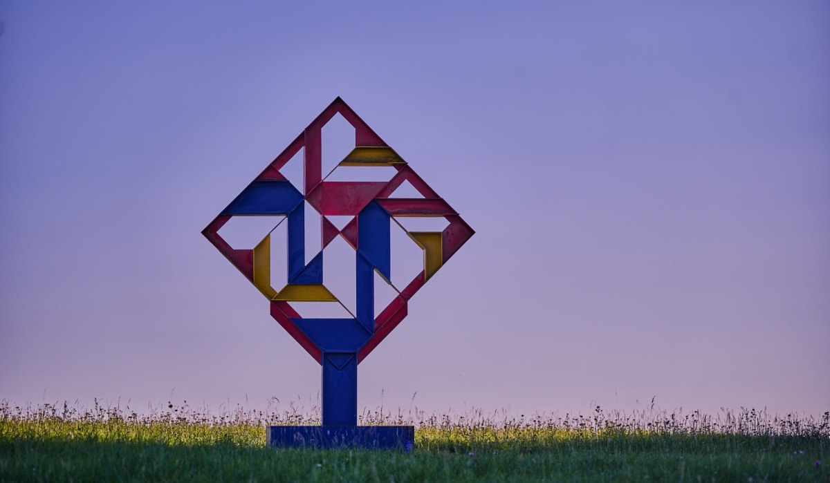 Bunte geometrische Skulptur auf einer Wiese, vor einem violetten Himmel. Die Skulptur besteht aus roten, blauen und gelben Elementen in einem quadratischen Muster., © Natur.Nah. Schönbuch & Heckengäu Bunte geometrische Skulptur auf einer Wiese, vor einem violetten Himmel. Die Skulptur besteht aus roten, blauen und gelben Elementen in einem quadratischen Muster., © Natur.Nah. Schönbuch & Heckengäu