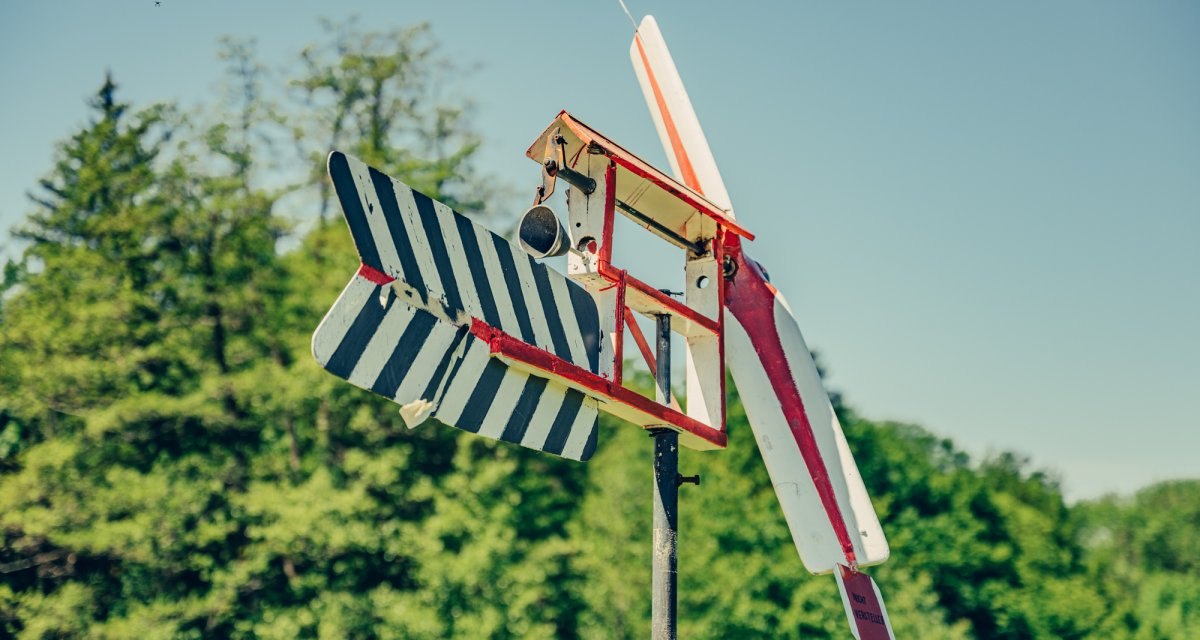 Ein buntes Holzflugzeugmodell auf einem Pfosten vor einem bewaldeten Hintergrund unter klarem Himmel., © Tourismus Ostalb Ein buntes Holzflugzeugmodell auf einem Pfosten vor einem bewaldeten Hintergrund unter klarem Himmel., © Tourismus Ostalb