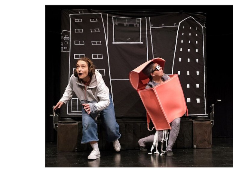 Zwei Personen auf einer Bühne, eine in Alltagskleidung, die andere in einem roten Kostüm, vor einem Hintergrund mit gezeichneten Gebäuden., © Kulturbüro Schwäbisch Gmünd