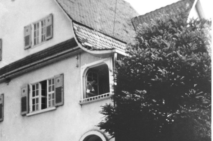 Ein historisches Geb&auml;ude mit einem markanten Dach und Fensterl&auml;den. Ein Baum verdeckt teilweise die Ansicht. Eine Person steht am Fenster., &copy; Stadt N&uuml;rtingen