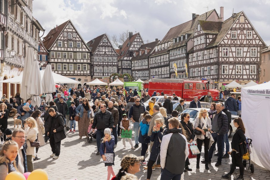 Menschenmenge auf einem belebten Marktplatz mit historischen Fachwerkhäusern und Ständen. Ein rotes Fahrzeug und ein Zelt sind ebenfalls zu sehen., © Stadt Schorndorf Menschenmenge auf einem belebten Marktplatz mit historischen Fachwerkhäusern und Ständen. Ein rotes Fahrzeug und ein Zelt sind ebenfalls zu sehen., © Stadt Schorndorf