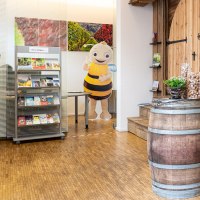 Innenansicht einer Tourist-Info mit Prospektständern, einem Weinfass und einer Bienenfigur. Helle, einladende Atmosphäre., © Remstal Tourismus, Peter Schuster Innenansicht einer Tourist-Info mit Prospektständern, einem Weinfass und einer Bienenfigur. Helle, einladende Atmosphäre., © Remstal Tourismus, Peter Schuster