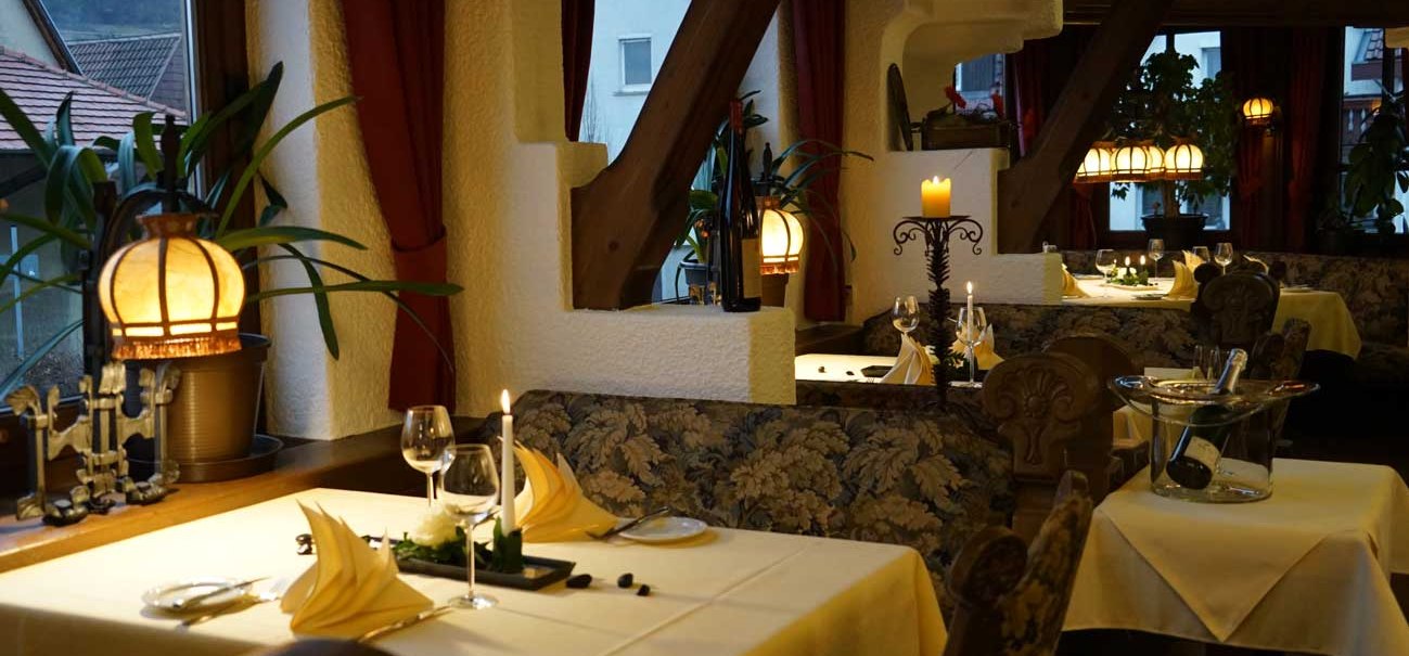 Ein gemütliches Restaurant mit Kerzenlicht, gedeckten Tischen und dekorativen Pflanzen. Die Atmosphäre wirkt einladend und romantisch., © Hotel & Restaurant Beurener Hof Ein gemütliches Restaurant mit Kerzenlicht, gedeckten Tischen und dekorativen Pflanzen. Die Atmosphäre wirkt einladend und romantisch., © Hotel & Restaurant Beurener Hof