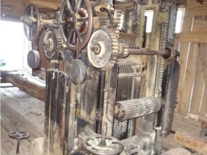 Eine alte mechanische Maschine mit Zahnrädern und Hebeln steht in einer rustikalen Holzhütte. Die Maschine wirkt verrostet und unbenutzt., © SwabianTravel Eine alte mechanische Maschine mit Zahnrädern und Hebeln steht in einer rustikalen Holzhütte. Die Maschine wirkt verrostet und unbenutzt., © SwabianTravel