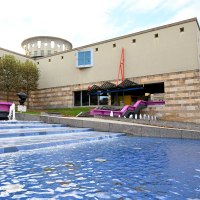 Das Haus der Geschichte zeigt moderne Architektur mit einem Brunnen im Vordergrund. B&auml;ume s&auml;umen das Geb&auml;ude, das durch klare Linien und Farben besticht., &copy; Haus der Geschichte Baden-W&uuml;rttemberg