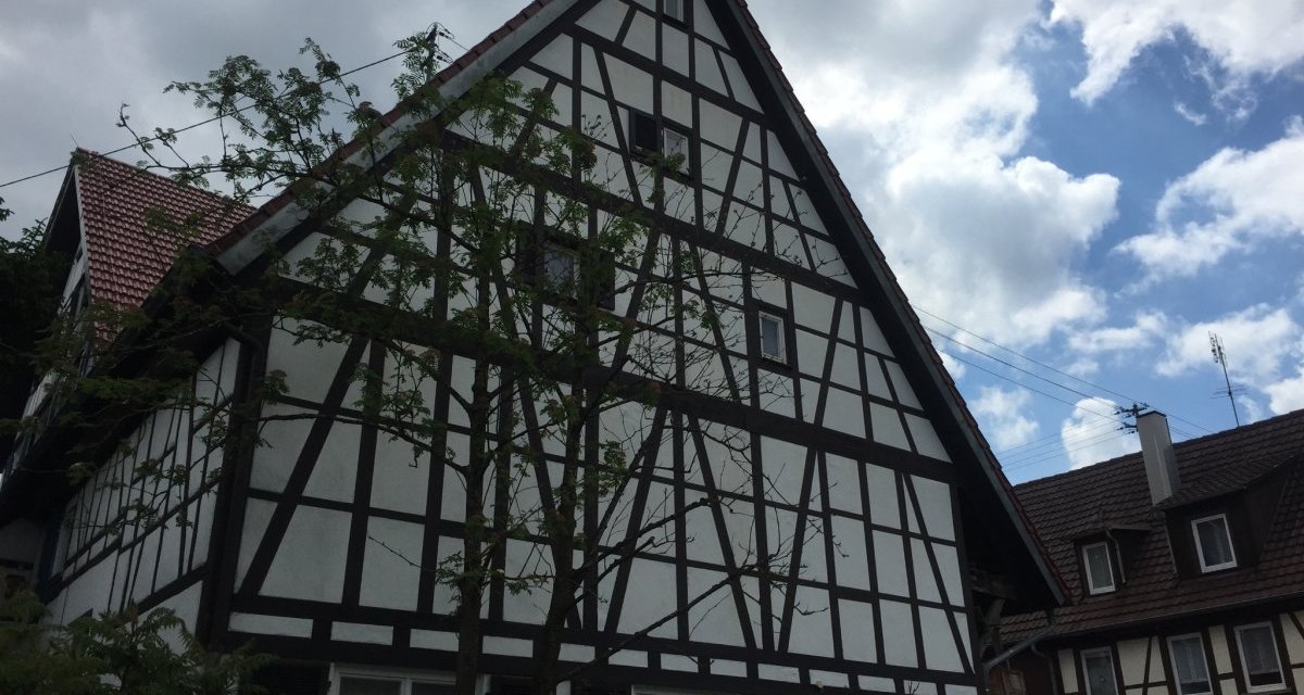 Ein traditionelles Fachwerkhaus mit dunklen Holzbalken und weißer Fassade. Das rote Ziegeldach und der bewölkte Himmel ergänzen die Szene., © Natur.Nah. Schönbuch & Heckengäu Ein traditionelles Fachwerkhaus mit dunklen Holzbalken und weißer Fassade. Das rote Ziegeldach und der bewölkte Himmel ergänzen die Szene., © Natur.Nah. Schönbuch & Heckengäu
