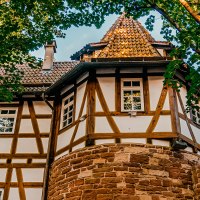 Fachwerkhaus mit rundem Turm, umgeben von B&auml;umen. Der Turm hat ein spitzes Dach, das Geb&auml;ude ist aus Holz und Stein gebaut., &copy; Stuttgart-Marketing GmbH, Thomas Niederm&uuml;ller