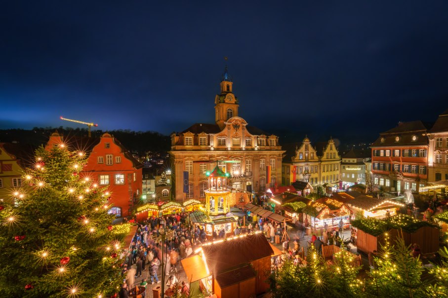 Beleuchtete Weihnachtspyramide und geschmückter Baum auf dem Weihnachtsmarkt in Schwäbisch Hall, umgeben von Menschen in festlicher Stimmung., © Michael Kuehneisen Beleuchtete Weihnachtspyramide und geschmückter Baum auf dem Weihnachtsmarkt in Schwäbisch Hall, umgeben von Menschen in festlicher Stimmung., © Michael Kuehneisen