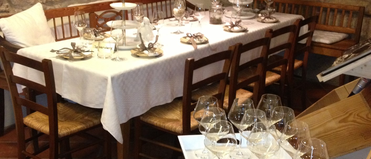 Ein rustikales Restaurant mit einem gedeckten Tisch, umgeben von Steinw&auml;nden. Weinflaschen und Gl&auml;ser sind dekorativ angeordnet., &copy; StadtNuertingen