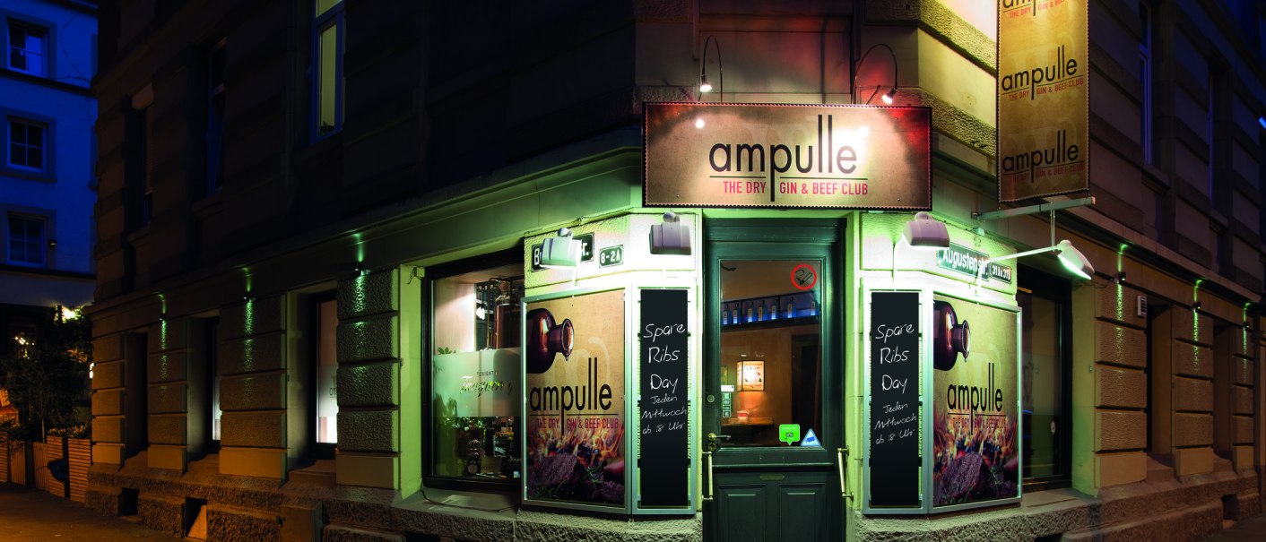 Eingang des Ampulle Gin & Beef Clubs bei Nacht, beleuchtetes Schild und Werbetafeln für Spare Ribs Day. Gebäude an einer Straßenecke., © © Buschwerk Mediendesign-Wilhelmer Gastronomie Eingang des Ampulle Gin & Beef Clubs bei Nacht, beleuchtetes Schild und Werbetafeln für Spare Ribs Day. Gebäude an einer Straßenecke., © © Buschwerk Mediendesign-Wilhelmer Gastronomie