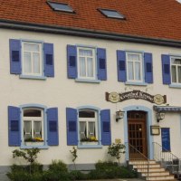 Ein traditionelles Gasthaus mit blauen Fensterläden und einem Schild mit der Aufschrift 'Gasthof Krone'., © Gasthof zur Krone