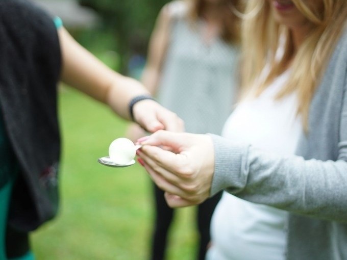 Zwei Personen spielen ein Ei-und-Löffel-Spiel im Freien. Eine Person hält den Löffel mit einem Ei, während die andere hilft., © Cool-Tours StattReisen Zwei Personen spielen ein Ei-und-Löffel-Spiel im Freien. Eine Person hält den Löffel mit einem Ei, während die andere hilft., © Cool-Tours StattReisen