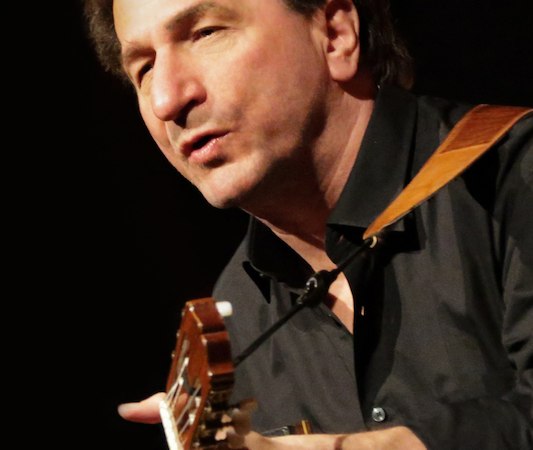 Ein Mann in einem schwarzen Hemd spielt Gitarre und singt leidenschaftlich auf einer Bühne., © Schönblick gemeinnützige GmbH