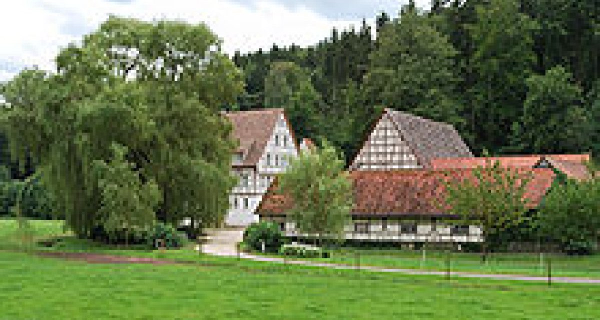Fachwerkhäuser in idyllischer Landschaft, umgeben von Bäumen und grüner Wiese. Ein Weg führt zu den Gebäuden., © Natur.Nah. Schönbuch & Heckengäu Fachwerkhäuser in idyllischer Landschaft, umgeben von Bäumen und grüner Wiese. Ein Weg führt zu den Gebäuden., © Natur.Nah. Schönbuch & Heckengäu