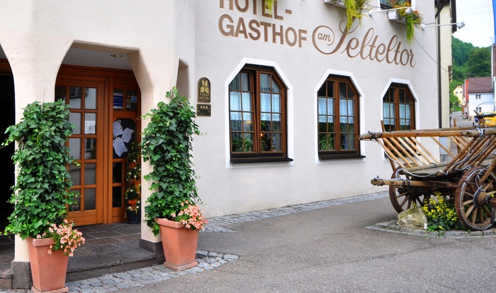 Eingang des Hotel-Gasthofs am Selteltor mit Pflanzen geschmückt. Ein alter Holzwagen steht daneben., © R.Storr