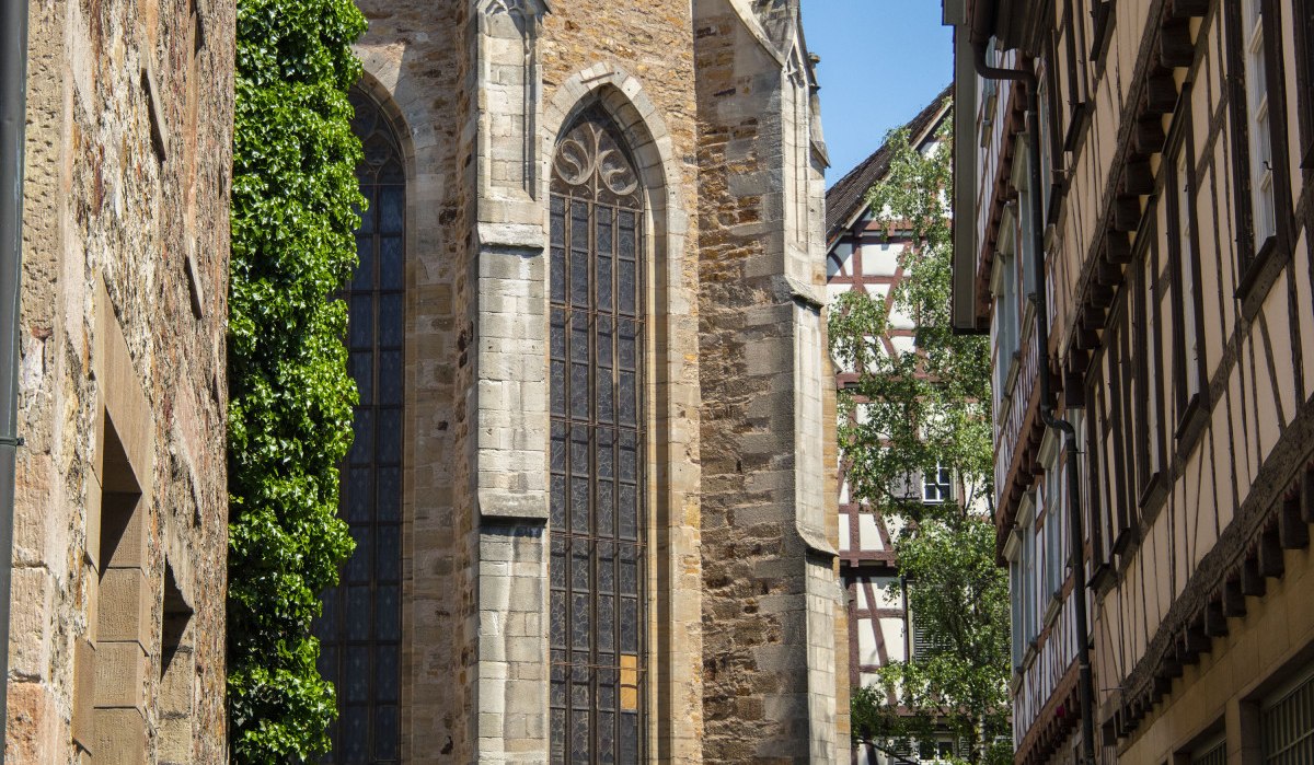 Gotische Martinskirche mit hohen Fenstern, umgeben von Fachwerkhäusern und einem Straßenschild im Vordergrund. Sonniger Tag, blauer Himmel., © Stadt Kirchheim unter Teck Gotische Martinskirche mit hohen Fenstern, umgeben von Fachwerkhäusern und einem Straßenschild im Vordergrund. Sonniger Tag, blauer Himmel., © Stadt Kirchheim unter Teck