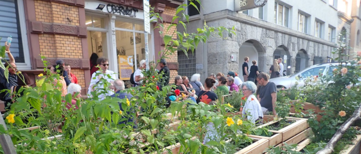 Menschen genießen einen urbanen Garten vor einem Gebäude mit der Aufschrift 'Oberwelt'. Es herrscht eine entspannte Atmosphäre., © Oberwelt e.V. Menschen genießen einen urbanen Garten vor einem Gebäude mit der Aufschrift 'Oberwelt'. Es herrscht eine entspannte Atmosphäre., © Oberwelt e.V.