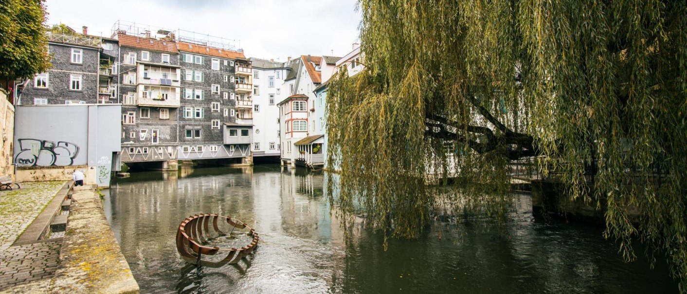 Ein malerischer Fluss in Esslingen, ges&auml;umt von historischen Geb&auml;uden und einer gro&szlig;en Trauerweide, die &uuml;ber das Wasser h&auml;ngt., &copy; Stuttgart-Marketing GmbH, Sarah Schmid