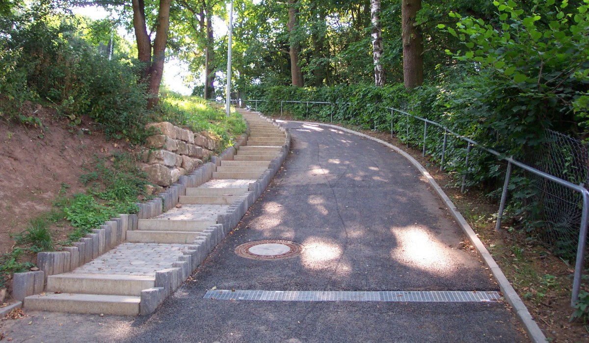Ein geteilter Weg mit Treppen und einer Rampe führt durch ein bewaldetes Gebiet. Links sind Stufen, rechts eine asphaltierte Rampe mit Geländer., © Natur.Nah. Schönbuch & Heckengäu Ein geteilter Weg mit Treppen und einer Rampe führt durch ein bewaldetes Gebiet. Links sind Stufen, rechts eine asphaltierte Rampe mit Geländer., © Natur.Nah. Schönbuch & Heckengäu