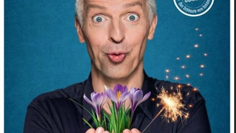 Ein Mann mit &uuml;berraschter Mimik h&auml;lt Krokusse und eine Wunderkerze vor einem blauen Hintergrund. Oben rechts steht "Comedy"., &copy; Touristik Bad Wildbad GmbH