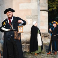 Ein Mann in historischer Kleidung mit Laterne und Hellebarde. Zwei weitere Personen in mittelalterlicher Kleidung im Hintergrund., &copy; Stadt N&uuml;rtingen, U. Jendrass