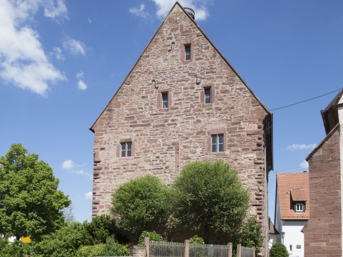 Historisches Geb&auml;ude aus rotem Sandstein in Merklingen, umgeben von B&auml;umen und blauem Himmel., &copy; Stadtverwaltung Weil der Stadt
